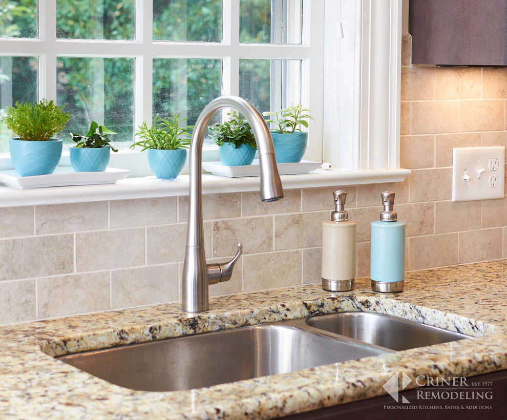 Inspiration for a transitional light wood floor eat-in kitchen remodel with shaker cabinets, dark wood cabinets, granite countertops, beige backsplash, glass tile backsplash, stainless steel appliances and an island