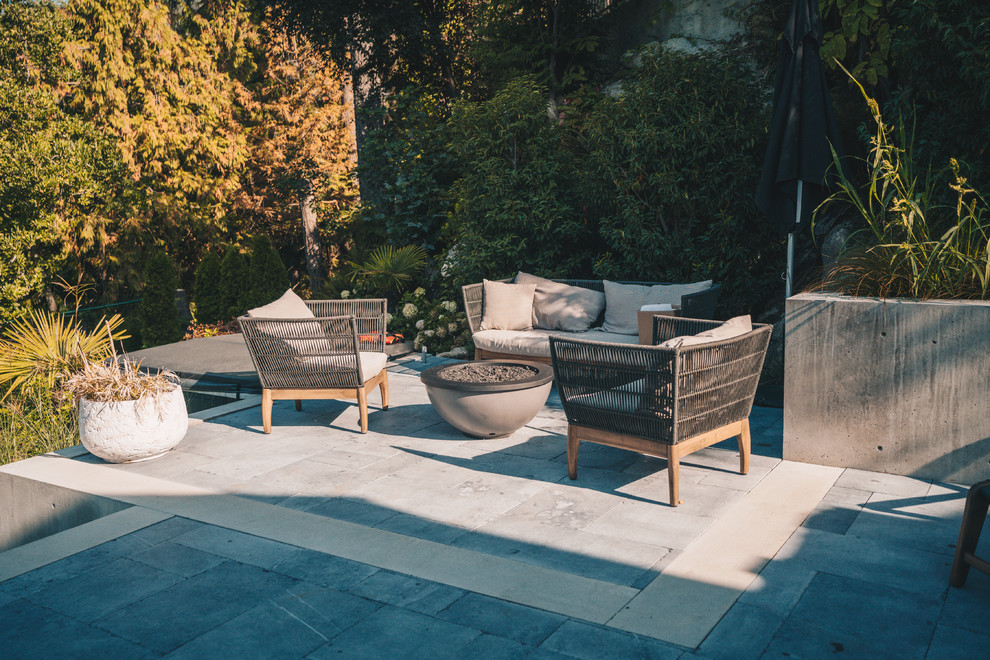Inspiration for a mid-sized contemporary backyard patio in Vancouver with a fire feature, concrete pavers and no cover.