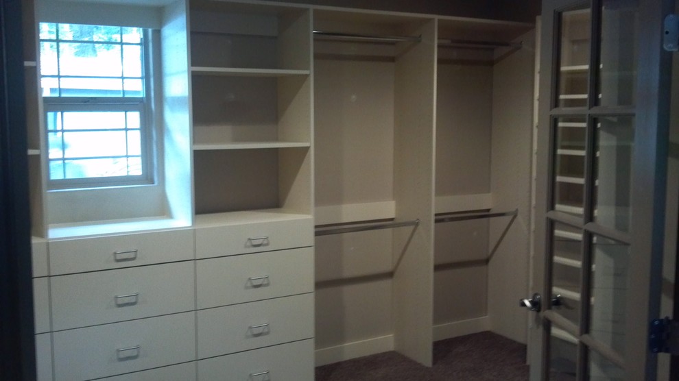 Design ideas for a mid-sized gender-neutral walk-in wardrobe in Other with flat-panel cabinets, white cabinets and carpet.