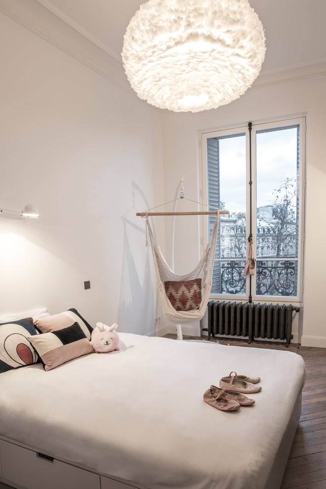 This is an example of a mid-sized contemporary kids' bedroom for kids 4-10 years old and girls in Paris with white walls and light hardwood floors.