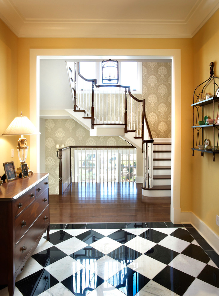 Photo of a traditional foyer in St Louis with yellow walls, marble floors and multi-coloured floor.