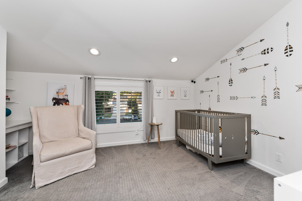 Aménagement d'une grande chambre de bébé neutre classique avec un mur beige, moquette, un sol gris et un plafond voûté.