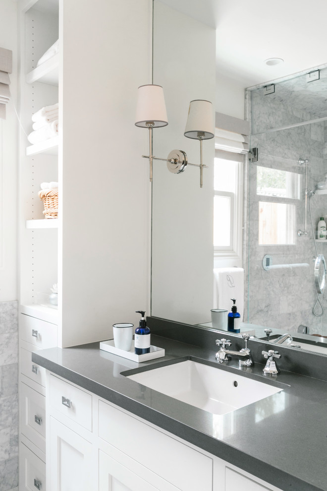 This is an example of a small transitional master bathroom in San Francisco with an undermount sink, recessed-panel cabinets, white cabinets, quartzite benchtops, a corner shower, gray tile, stone tile, white walls and marble floors.
