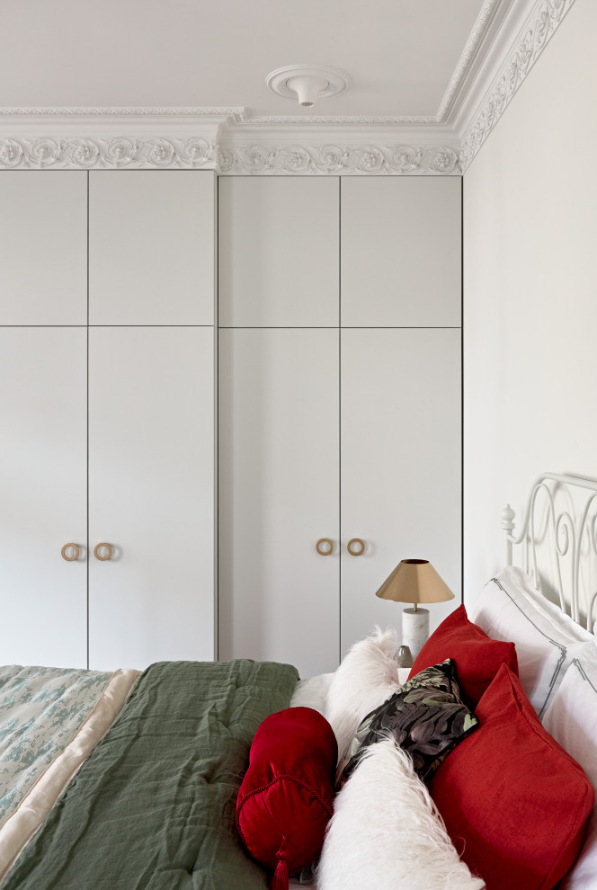 Idées déco pour une grande chambre classique avec un mur blanc, un sol en bois brun, une cheminée standard et un sol marron.