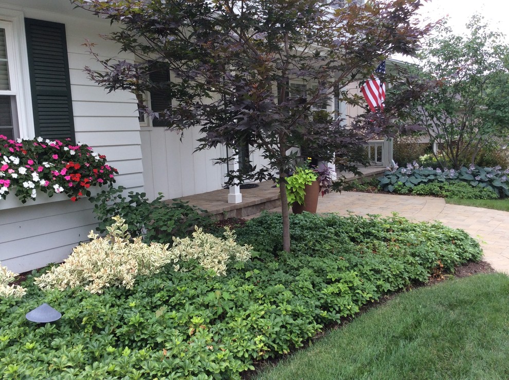 Mid-sized traditional front yard garden in Omaha with brick pavers.