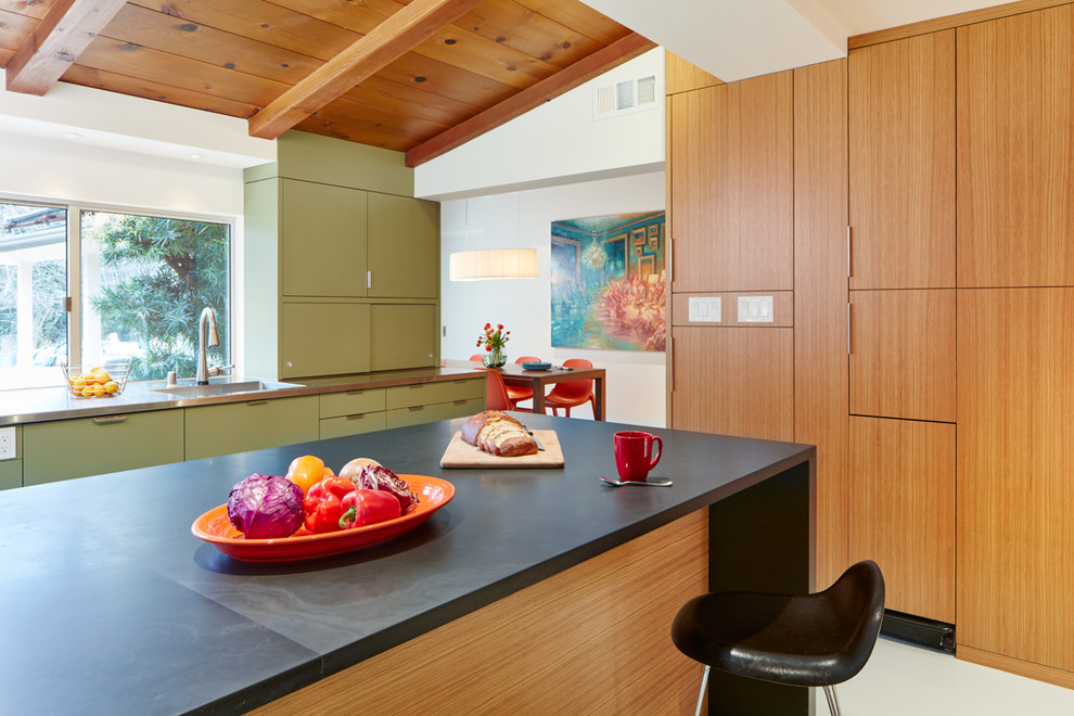 Inspiration for a midcentury kitchen in San Francisco with an integrated sink, flat-panel cabinets, green cabinets, stainless steel benchtops and with island.