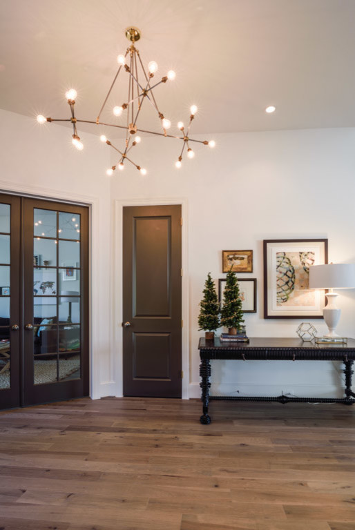Inspiration for a mid-sized transitional light wood floor foyer remodel in Houston with white walls and a dark wood front door