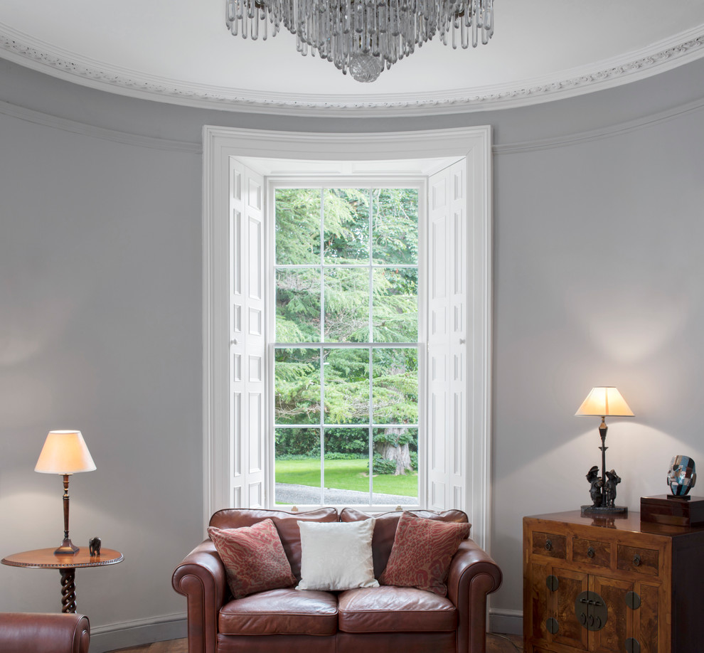 Inspiration for a mid-sized traditional living room in Dublin with grey walls and medium hardwood floors.