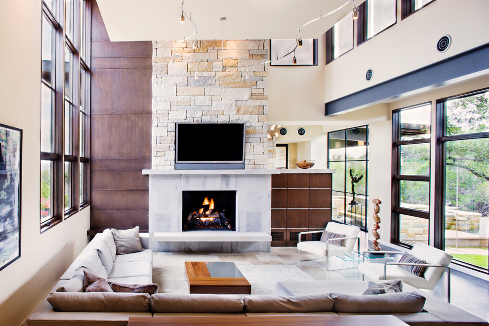This is an example of a mid-sized contemporary enclosed family room in Austin with beige walls, a standard fireplace, a wall-mounted tv, dark hardwood floors and brown floor.