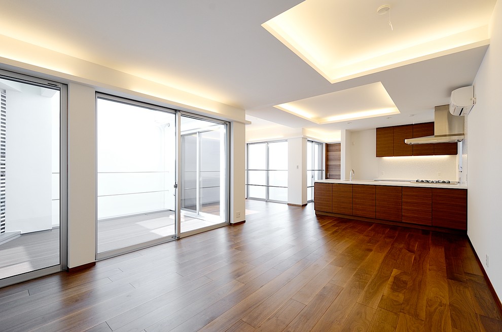Photo of a modern open concept living room in Tokyo with white walls, dark hardwood floors, no fireplace and beige floor.