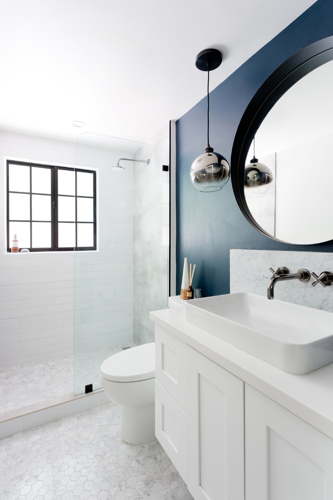 Photo of a small transitional 3/4 bathroom in Orange County with shaker cabinets, white cabinets, an alcove shower, a one-piece toilet, gray tile, white tile, marble, blue walls, marble floors, a vessel sink, engineered quartz benchtops, grey floor, an open shower and white benchtops.