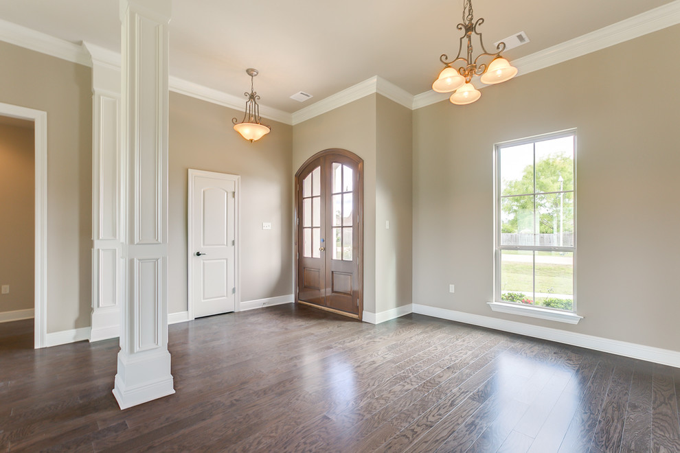 Photo of a country foyer in New Orleans with beige walls, dark hardwood floors, a double front door and a medium wood front door.