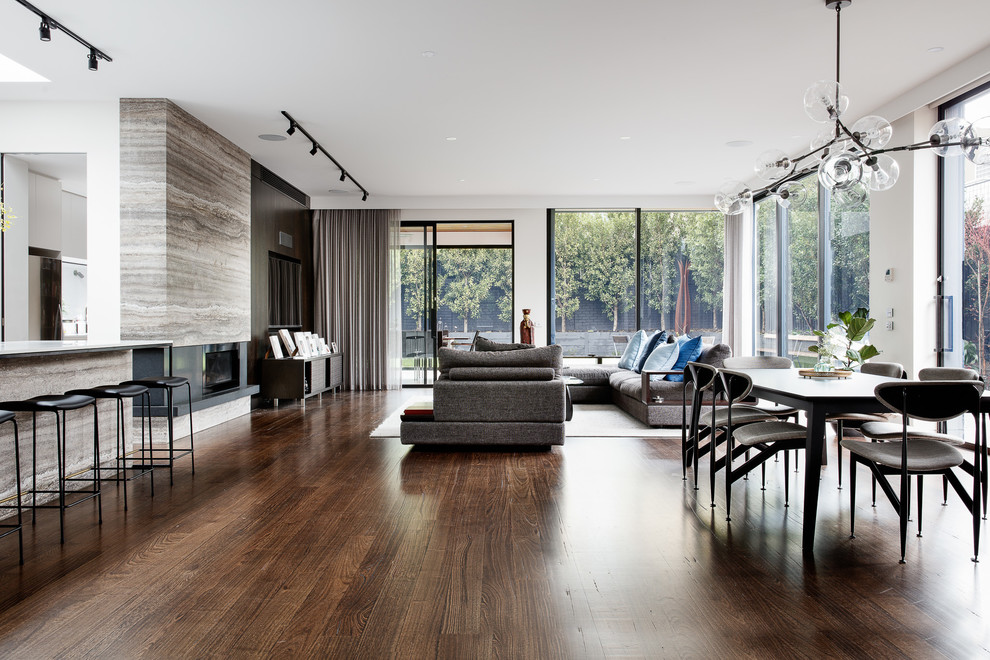 Large contemporary open plan dining in Melbourne with white walls, a ribbon fireplace, a stone fireplace surround, brown floor and dark hardwood floors.