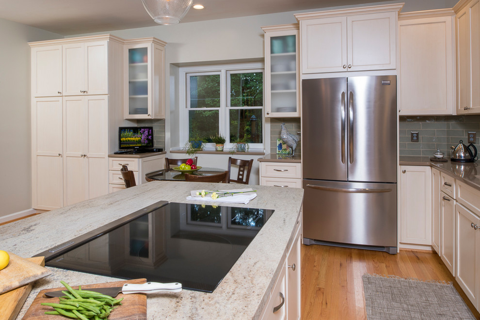 Eat-in kitchen - transitional l-shaped light wood floor eat-in kitchen idea in Raleigh with an undermount sink, shaker cabinets, blue backsplash, stainless steel appliances and an island