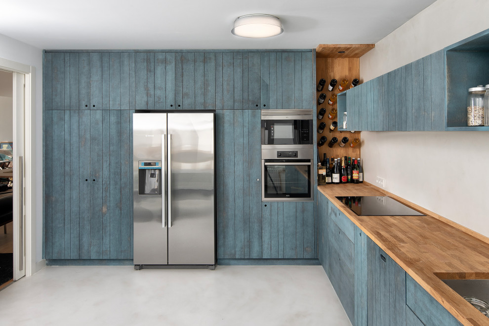 Mid-sized contemporary l-shaped kitchen in Other with an undermount sink, turquoise cabinets, wood benchtops, stainless steel appliances, no island, grey floor, beige benchtop and flat-panel cabinets.