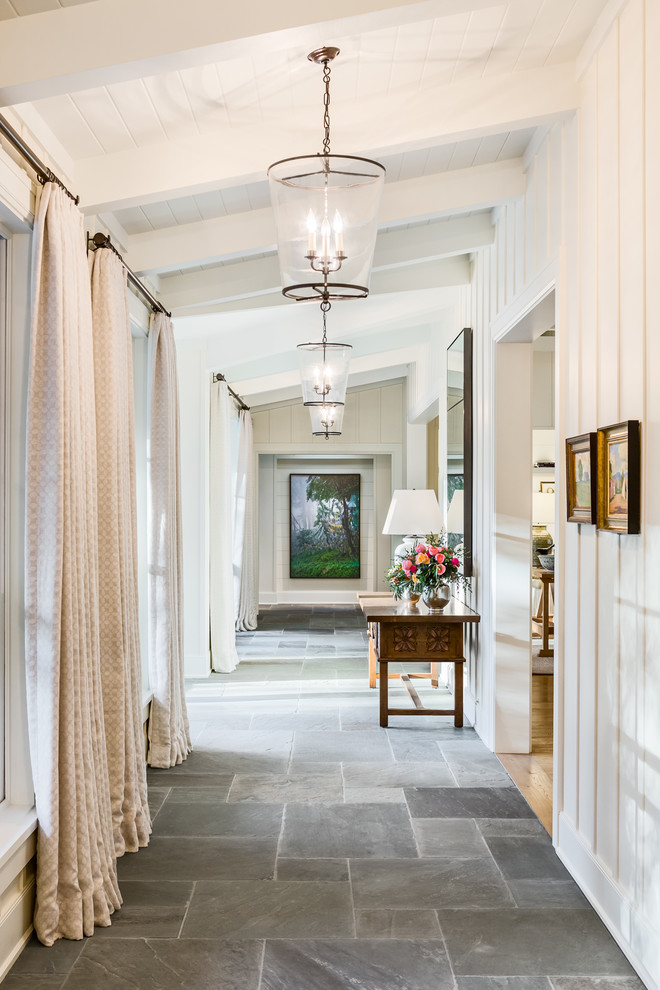 This is an example of a beach style hallway in Santa Barbara with white walls and grey floor.