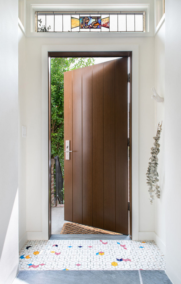 Foto di una piccola porta d'ingresso minimalista con pareti bianche, pavimento con piastrelle in ceramica, una porta singola, una porta marrone e pavimento multicolore