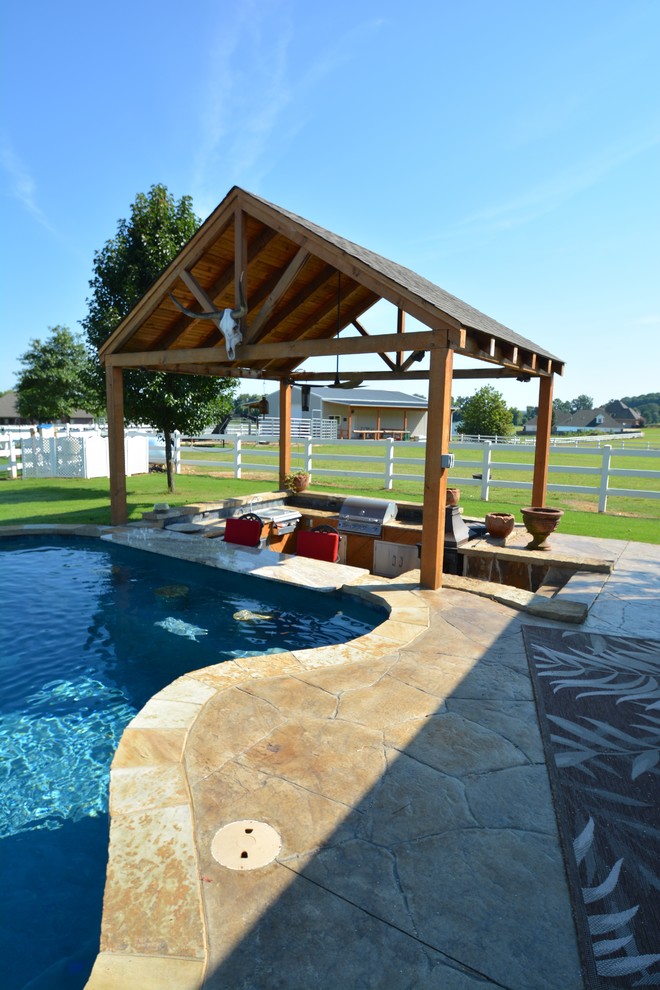 Design ideas for a large country backyard custom-shaped lap pool in Little Rock with a hot tub and stamped concrete.