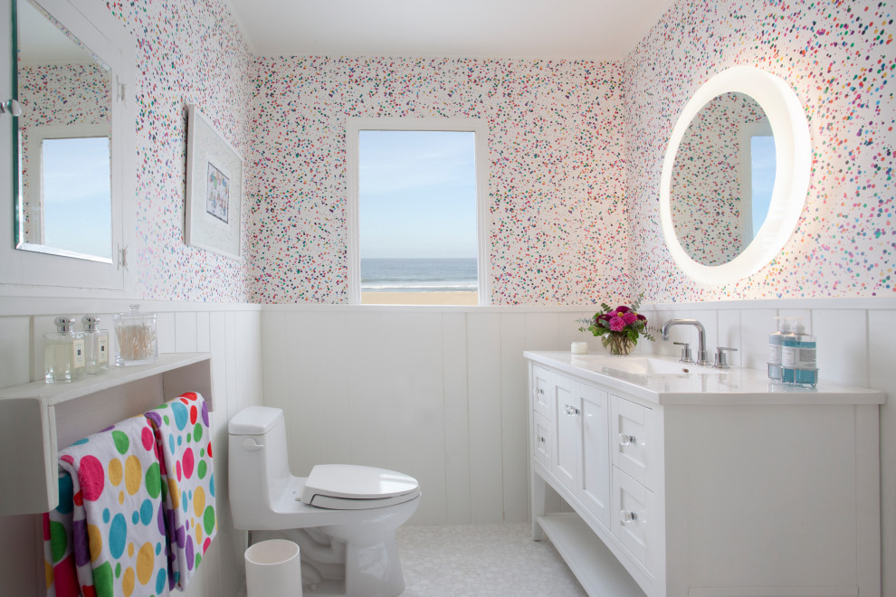 This is an example of a transitional bathroom in Los Angeles with shaker cabinets, white cabinets, multi-coloured walls, an undermount sink, white floor, white benchtops, a single vanity, a freestanding vanity, decorative wall panelling and wallpaper.