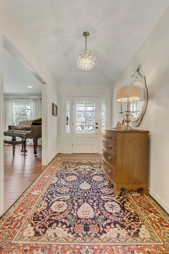 Photo of a mid-sized eclectic foyer in Dallas with white walls, medium hardwood floors, a single front door, a white front door and brown floor.