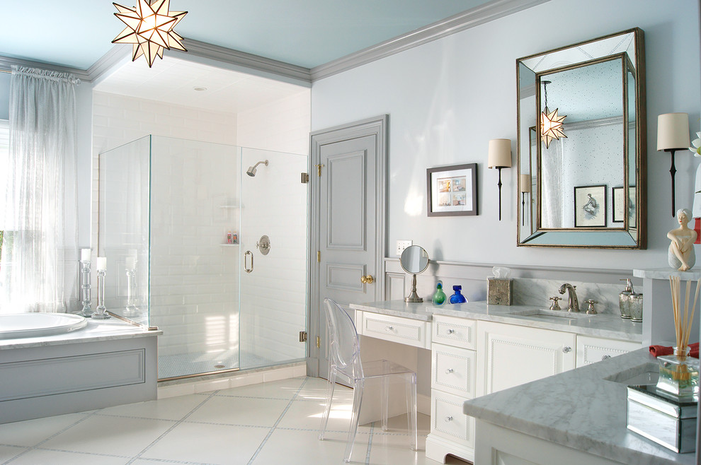 Inspiration for a mid-sized transitional master bathroom in New York with an undermount sink, white cabinets, a drop-in tub, a corner shower, white tile, subway tile, grey walls, beaded inset cabinets, porcelain floors, beige floor, a hinged shower door, a bidet and marble benchtops.