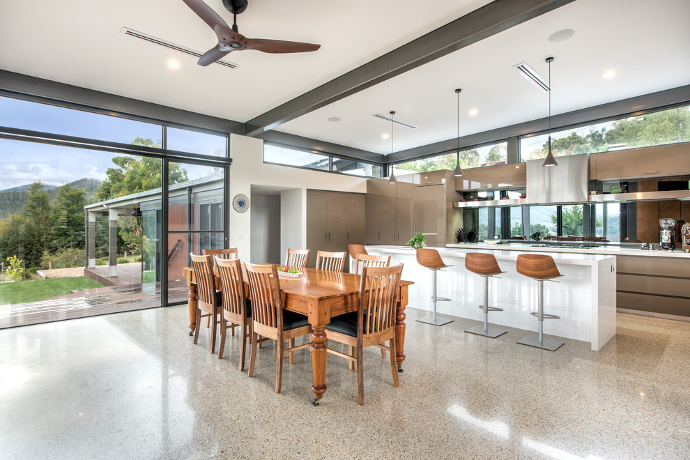 Design ideas for an expansive contemporary galley eat-in kitchen in Melbourne with an integrated sink, flat-panel cabinets, brown cabinets, granite benchtops, mirror splashback, stainless steel appliances, concrete floors and with island.