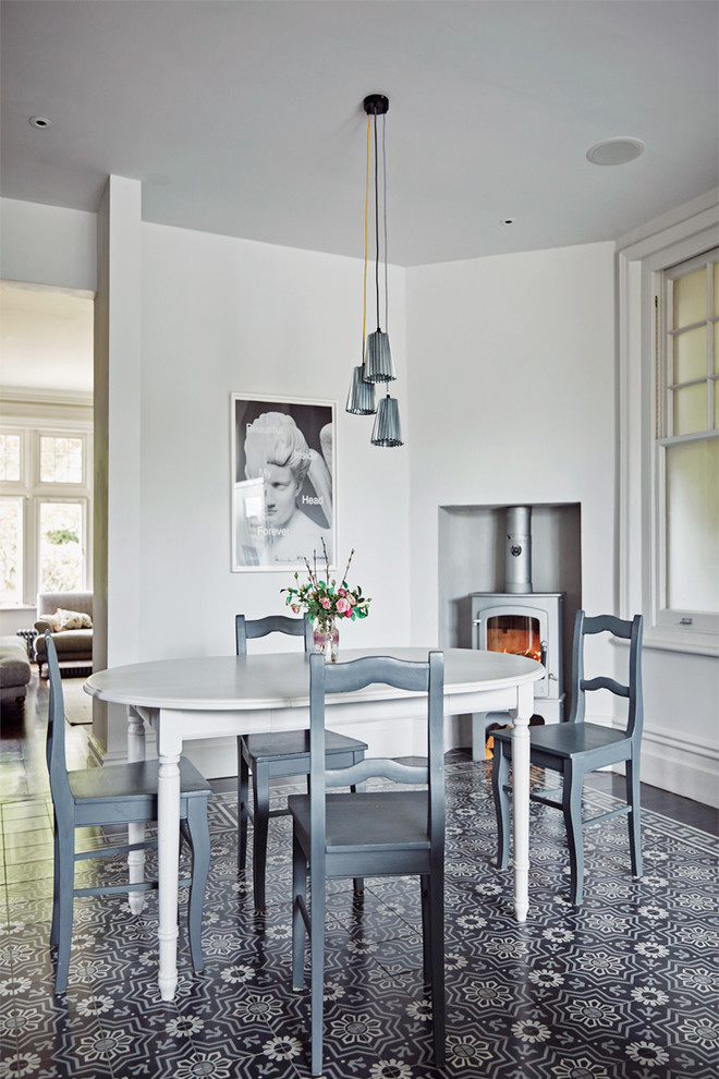 Inspiration for a classic dining room in London with white walls and a wood burning stove.