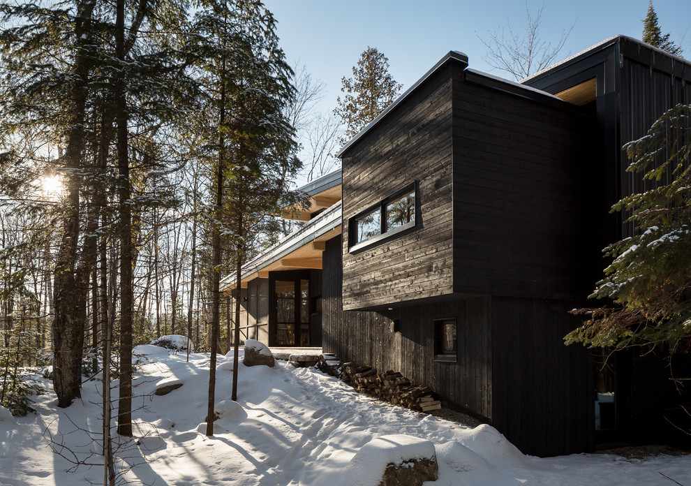 This is an example of a small country split-level black exterior in Montreal with wood siding.