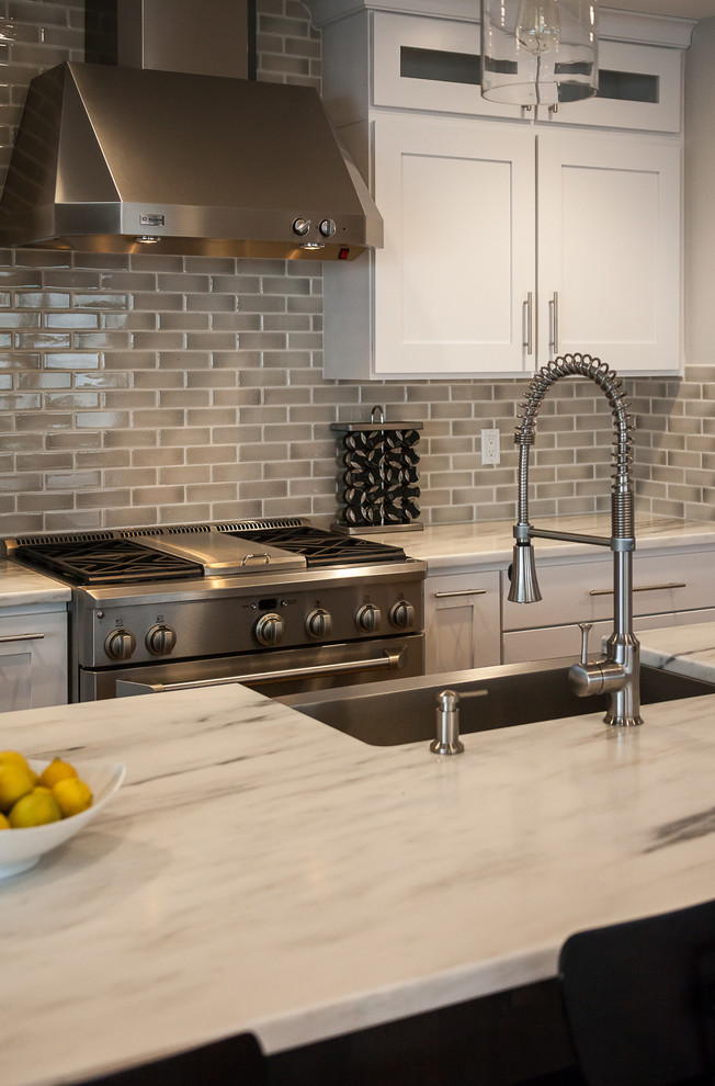 Inspiration for a contemporary kitchen in Denver with an undermount sink, shaker cabinets, white cabinets, granite benchtops, beige splashback, subway tile splashback, stainless steel appliances, medium hardwood floors and with island.