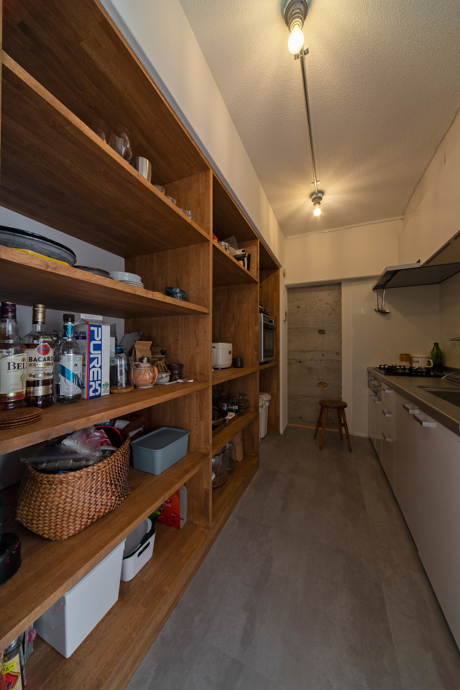 This is an example of a small industrial single-wall separate kitchen in Osaka with beaded inset cabinets, brown cabinets, white splashback, vinyl floors, with island, grey floor and wallpaper.