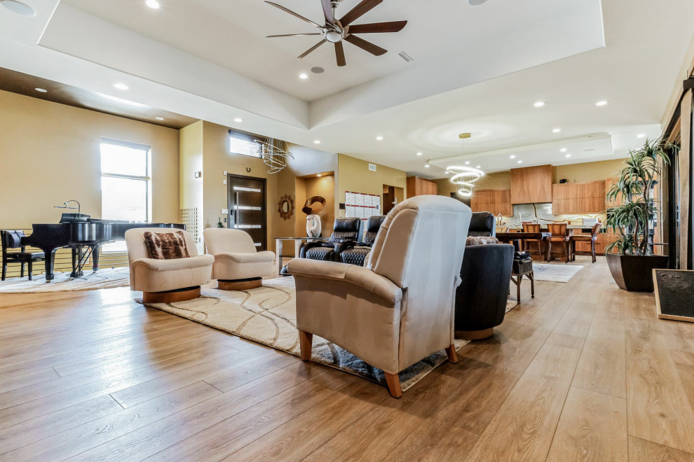 Inspiration for a mid-sized eclectic formal vinyl floor, beige floor and vaulted ceiling living room remodel in Denver with beige walls, a wood stove, a stone fireplace and a wall-mounted tv