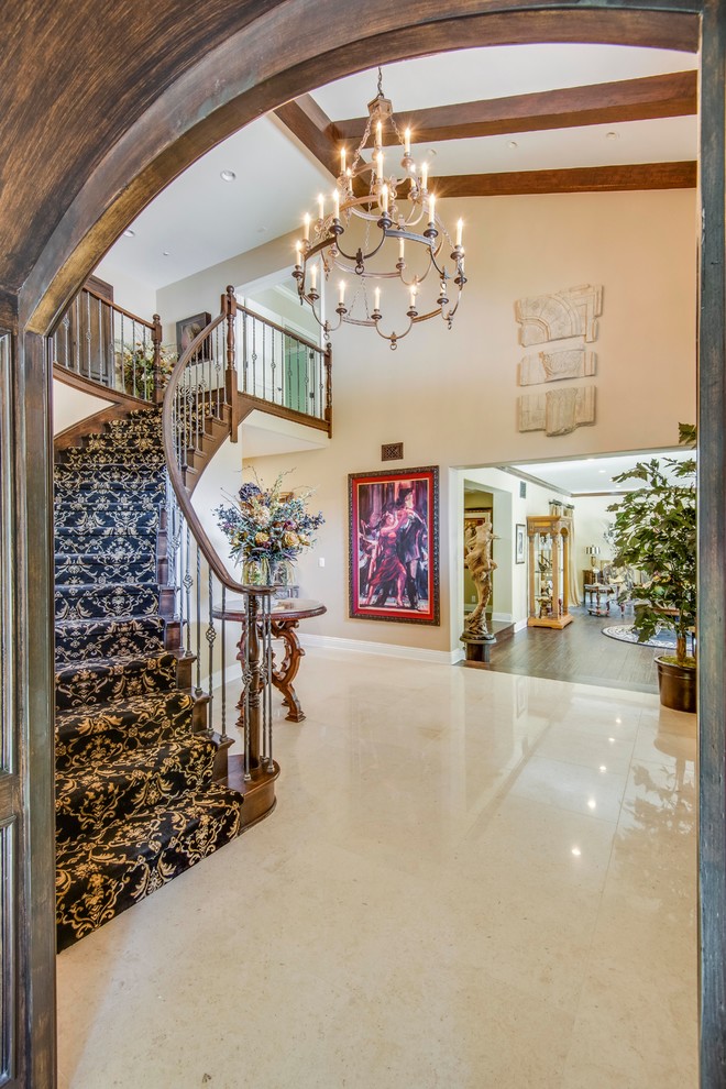 Inspiration for a large mediterranean foyer in Los Angeles with white walls and marble floors.