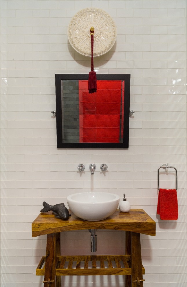 Photo of an asian powder room in Moscow with white tile, white walls, a vessel sink and open cabinets.