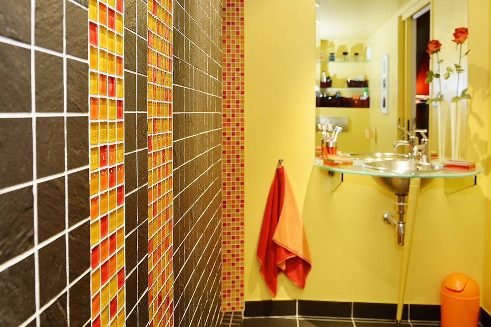 This is an example of a small contemporary 3/4 bathroom in Lyon with orange tile, mosaic tile, slate floors, a pedestal sink, glass benchtops and black floor.