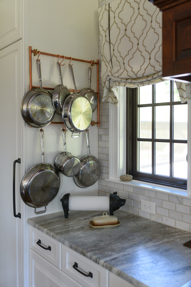 Inspiration for a large transitional l-shaped dark wood floor and brown floor kitchen remodel with an undermount sink, raised-panel cabinets, white cabinets, quartzite countertops, white backsplash, marble backsplash, stainless steel appliances and an island