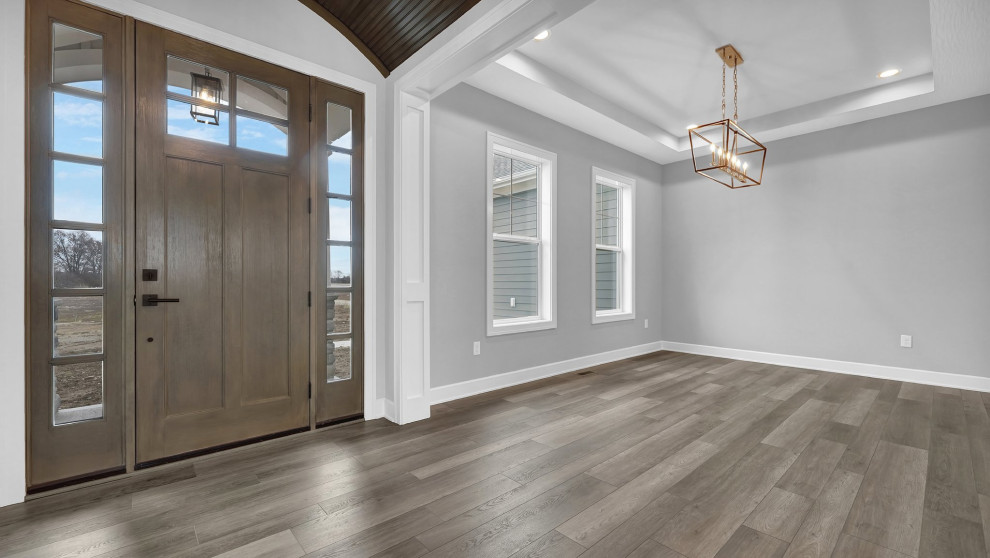 This is an example of a transitional foyer in Columbus with grey walls, laminate floors, a single front door, a medium wood front door and wood.