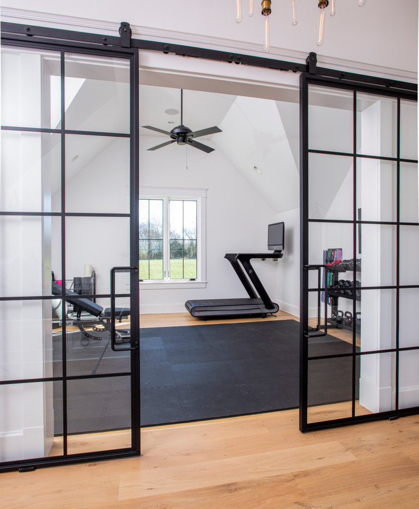 Example of a mid-sized farmhouse light wood floor, brown floor and vaulted ceiling multiuse home gym design in Nashville with white walls