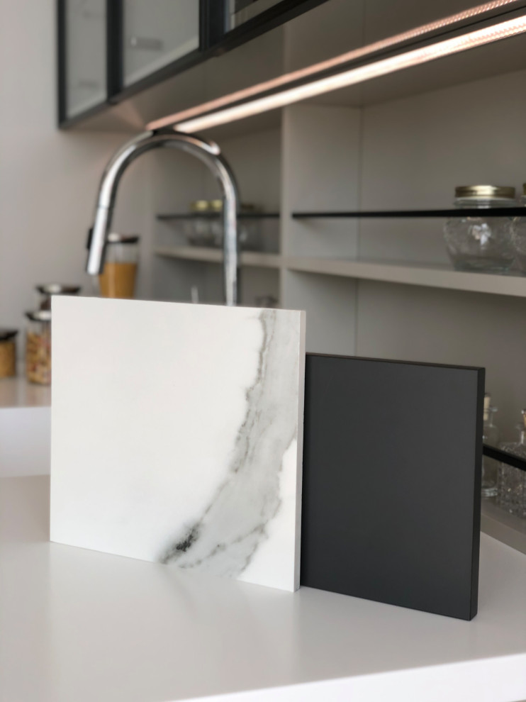 Inspiration for a small modern l-shaped eat-in kitchen in Other with an undermount sink, flat-panel cabinets, black cabinets, marble benchtops, white splashback, marble splashback, black appliances, ceramic floors, grey floor and white benchtop.