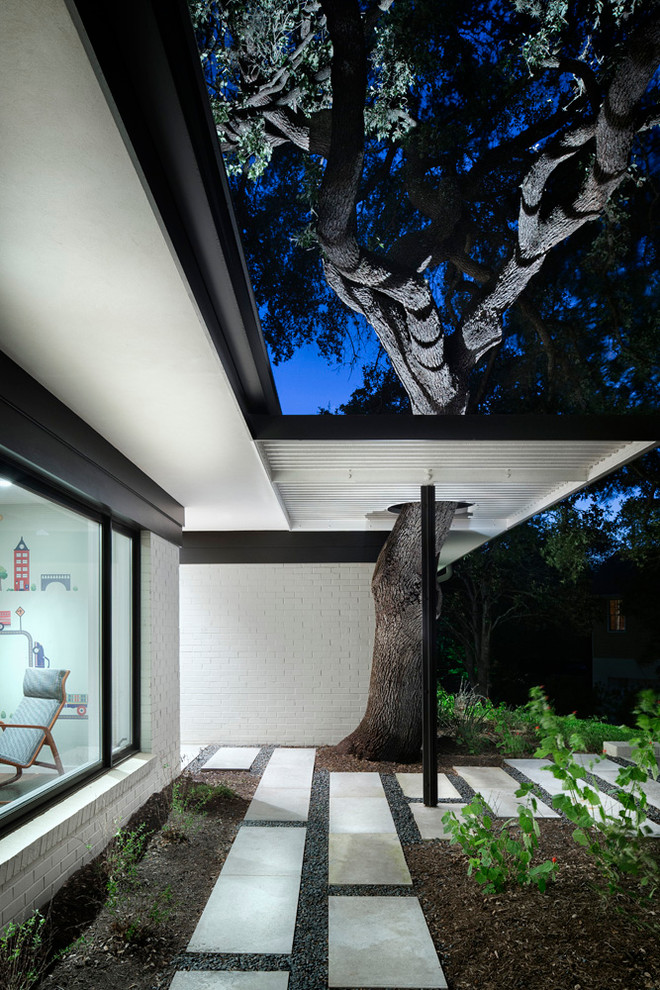 Photo of a large contemporary front yard verandah in Austin with concrete pavers.