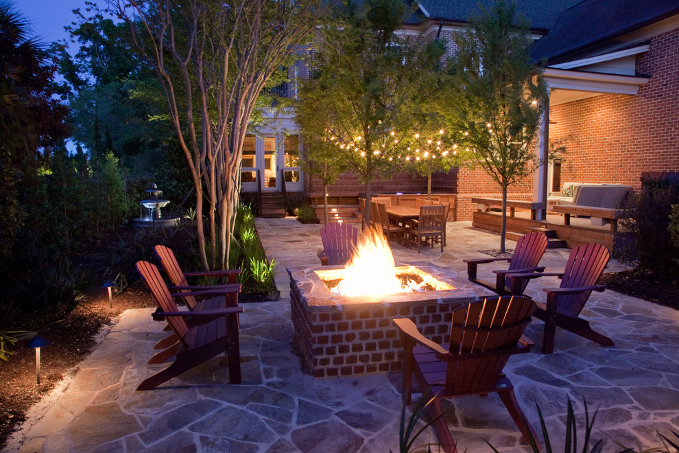 Patio - contemporary courtyard stone patio idea in Charleston with a fire pit