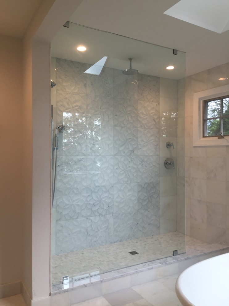 This is an example of a contemporary master bathroom in New York with an alcove shower, subway tile, white walls and marble floors.