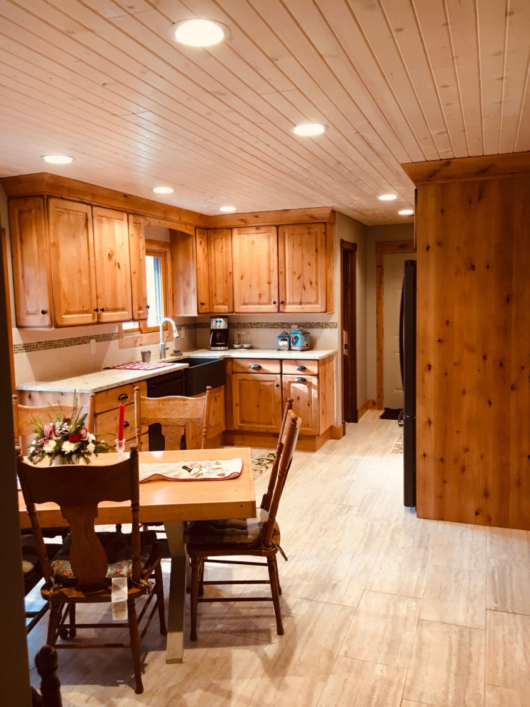 Mid-sized mountain style galley enclosed kitchen photo with a farmhouse sink, raised-panel cabinets, light wood cabinets, quartz countertops and no island