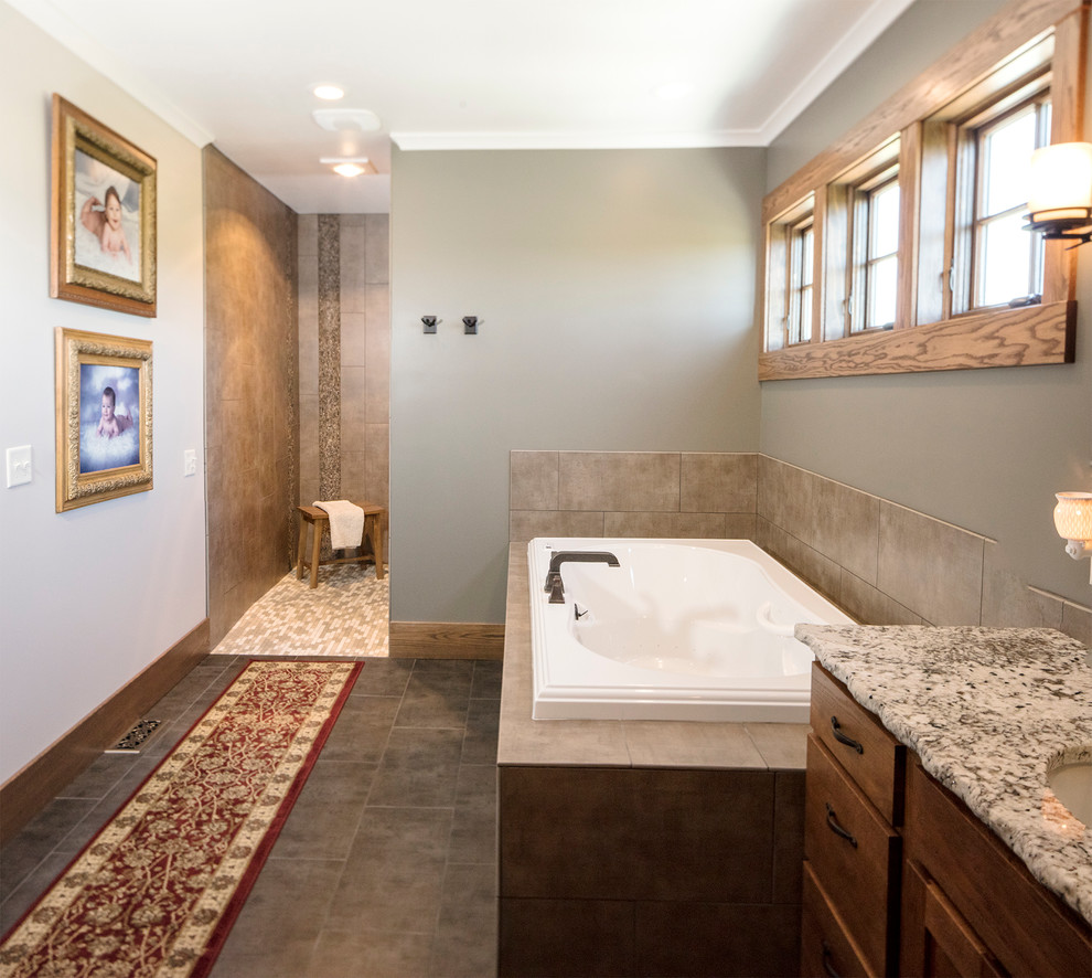 Drop-in bathtub - mid-sized craftsman master beige tile and porcelain tile porcelain tile and gray floor drop-in bathtub idea with shaker cabinets, medium tone wood cabinets, an undermount sink and granite countertops