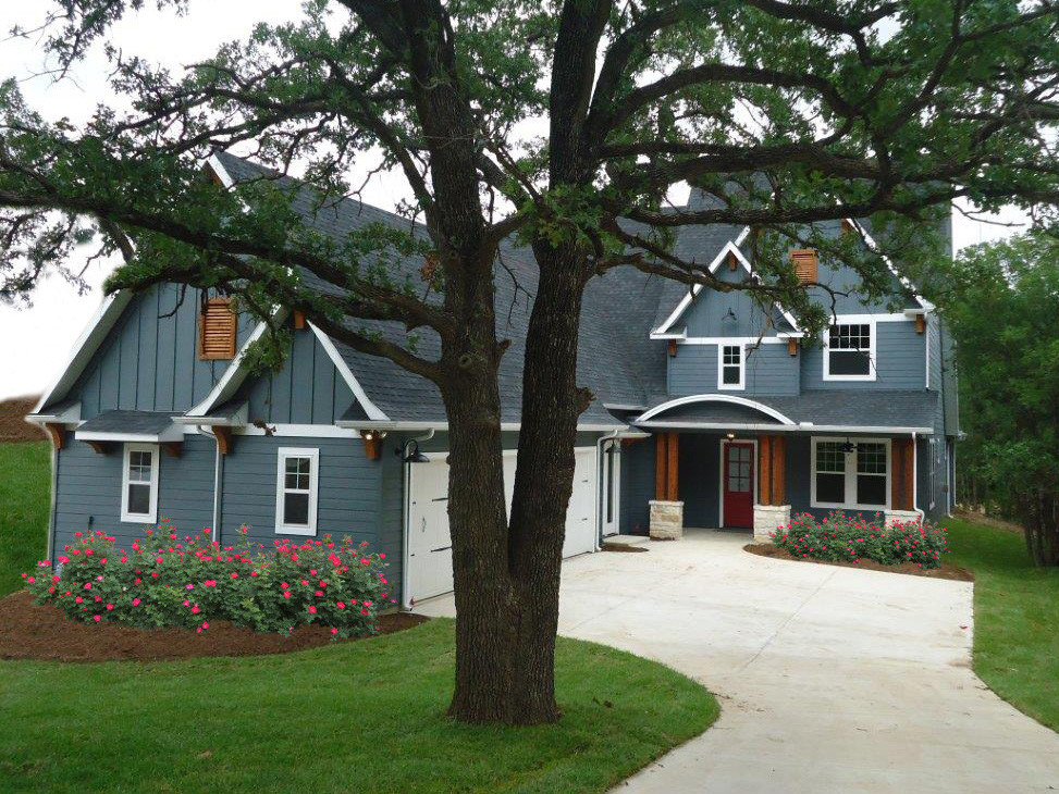 This is an example of a large arts and crafts two-storey blue exterior in Dallas with vinyl siding and a gable roof.