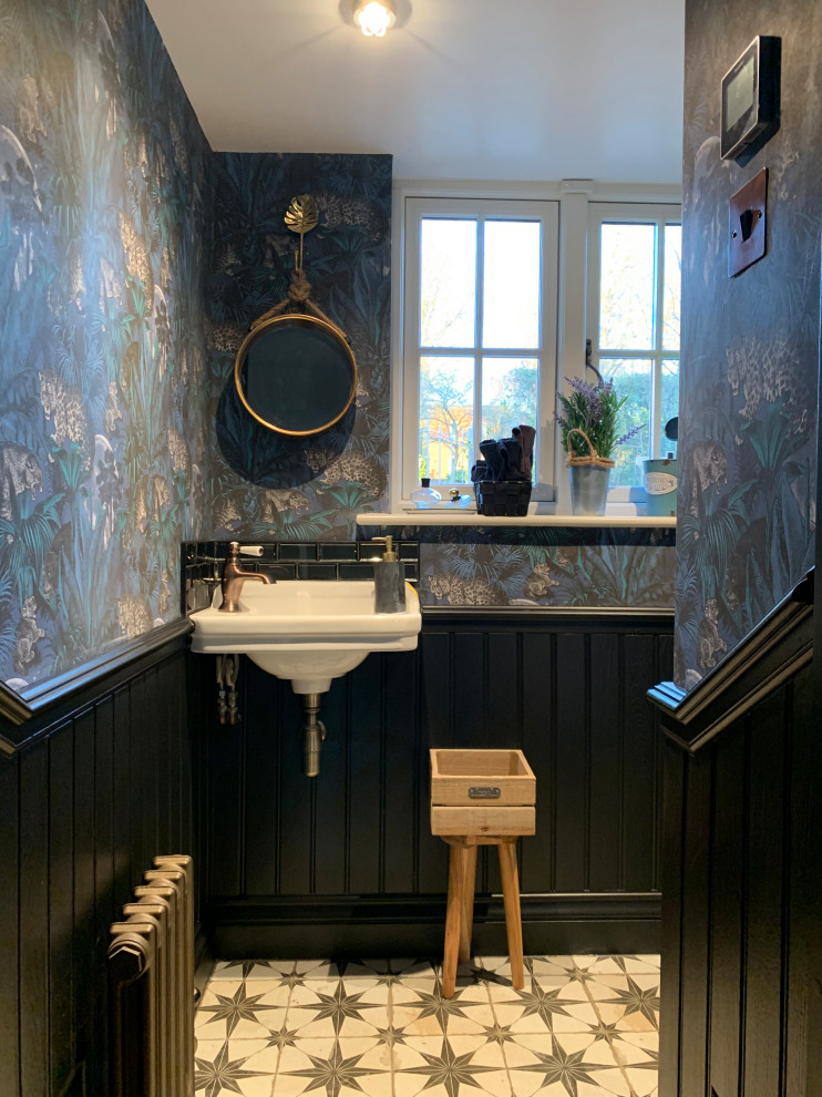Inspiration för ett litet eklektiskt toalett, med en toalettstol med separat cisternkåpa, svart kakel, glaskakel, blå väggar, klinkergolv i porslin, ett väggmonterat handfat och flerfärgat golv
