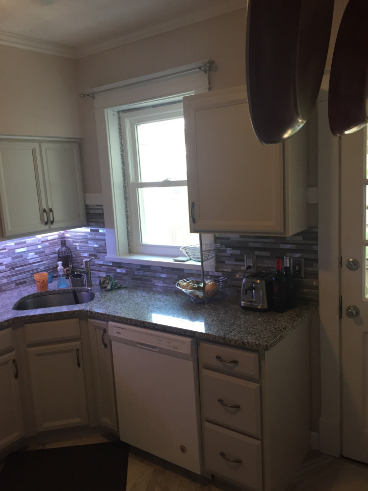 Mid-sized transitional l-shaped ceramic tile and gray floor kitchen photo in St Louis with an undermount sink, recessed-panel cabinets, gray cabinets, granite countertops, multicolored backsplash, glass sheet backsplash, white appliances and multicolored countertops