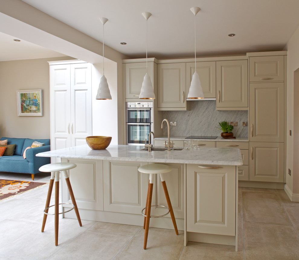 Inspiration for a transitional open plan kitchen in Dublin with an undermount sink, raised-panel cabinets, white cabinets, white splashback and stainless steel appliances.