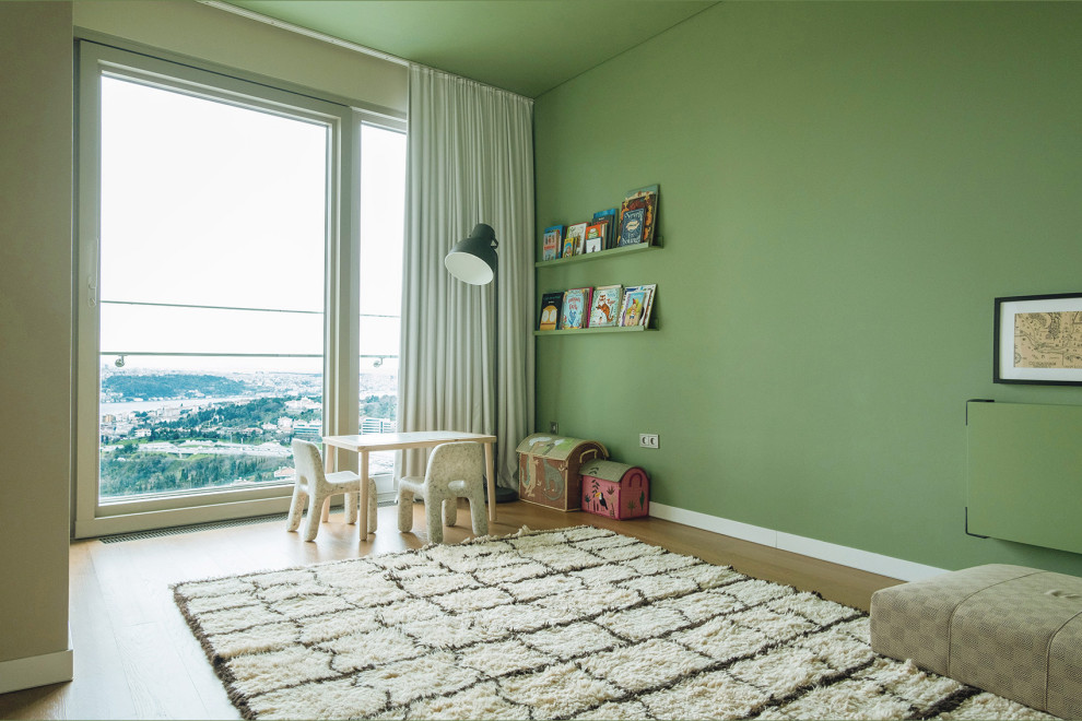 Aménagement d'une chambre neutre de 1 à 3 ans contemporaine de taille moyenne avec un mur vert, parquet clair et un sol marron.