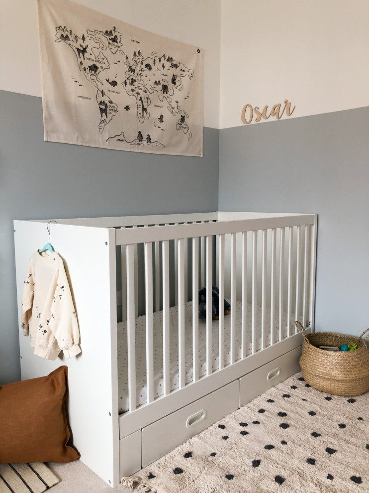 Photo of a small modern nursery for boys in Edinburgh with blue walls, carpet and beige floor.