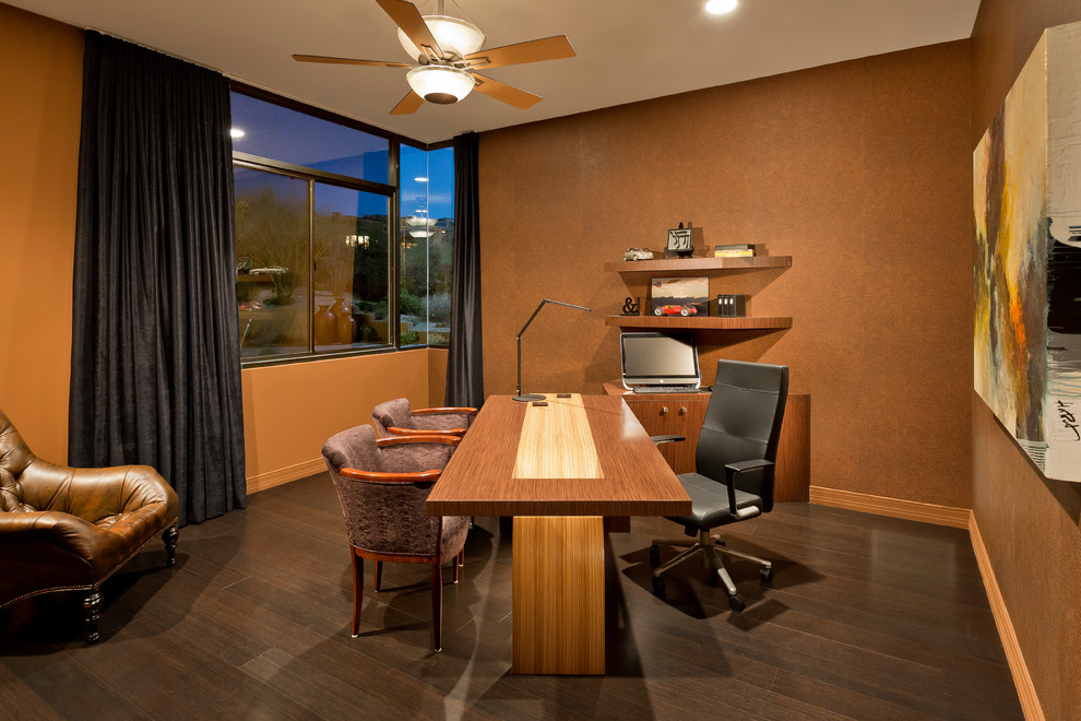 This is an example of a mid-sized contemporary study room in Phoenix with brown walls, dark hardwood floors, no fireplace and a freestanding desk.
